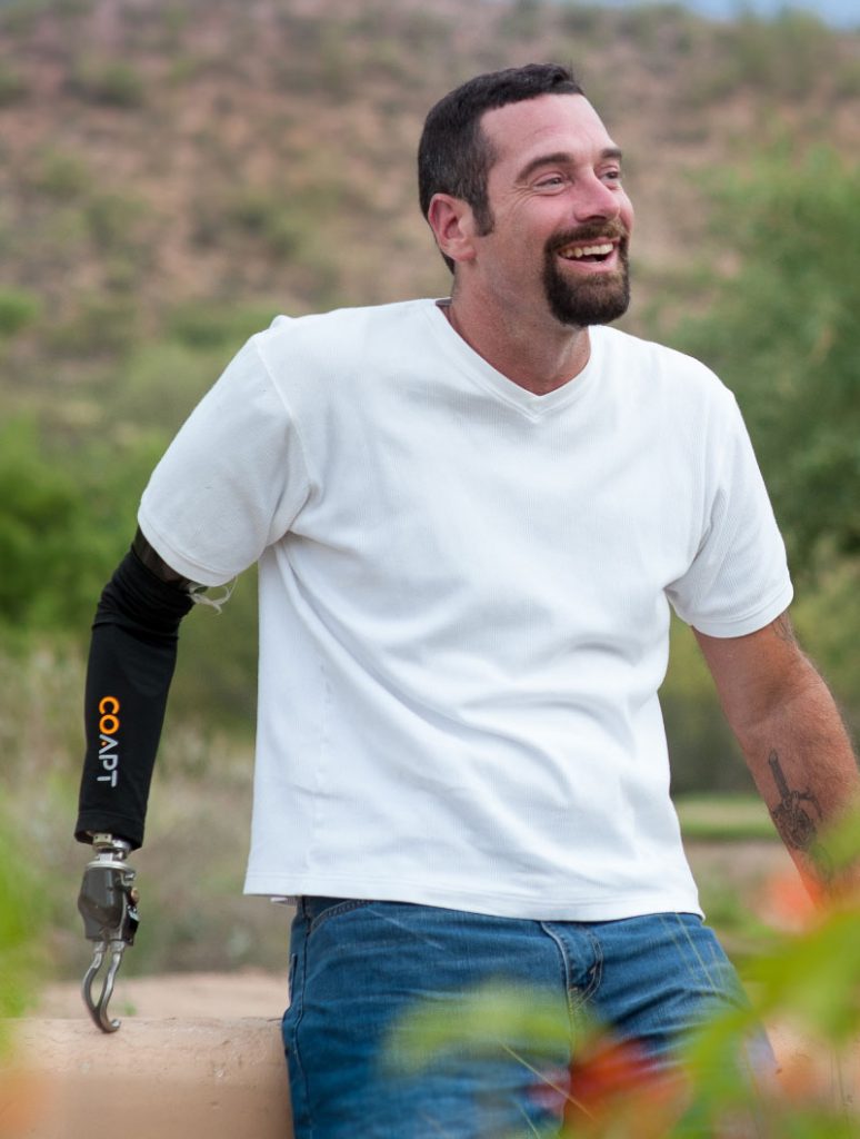 Coapt user leaning against a wall and smiling in Arizona