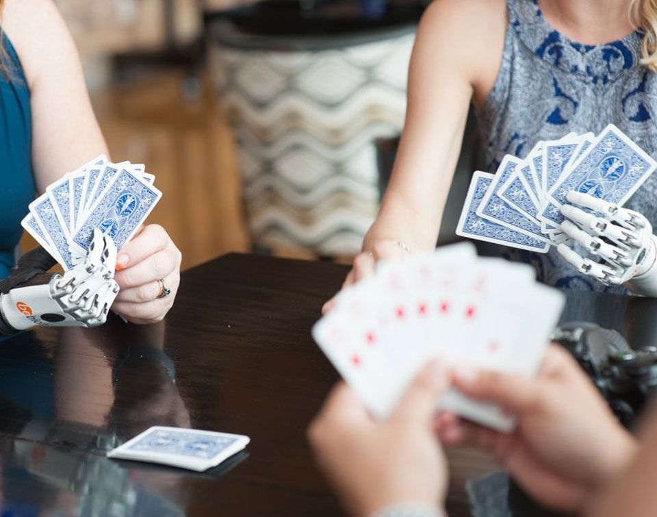 Close up of two Coapt users playing cards.